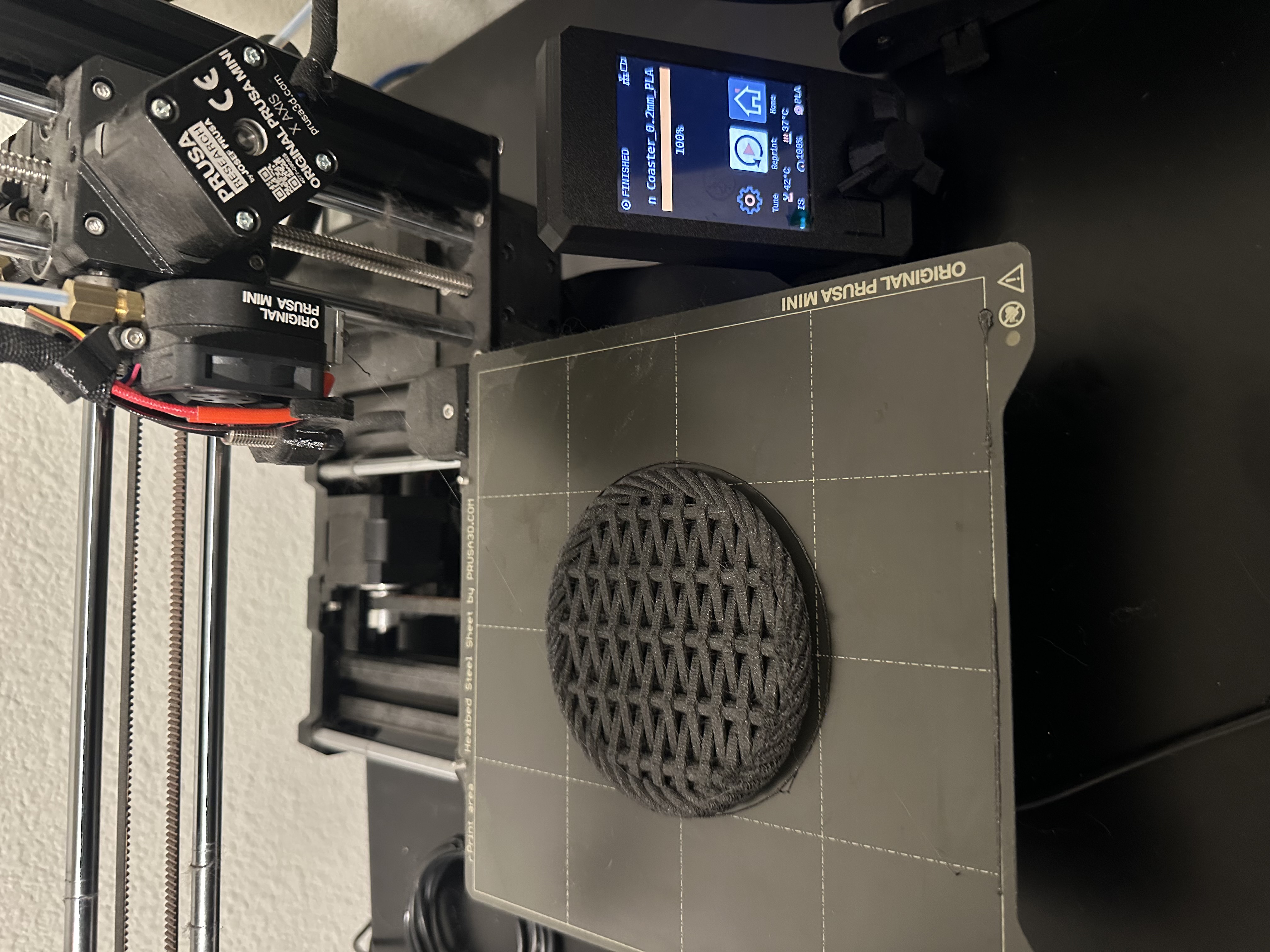 Finished textured coaster on Dillon's Prusa Mini print bed, Prusa screen showing FINISHED